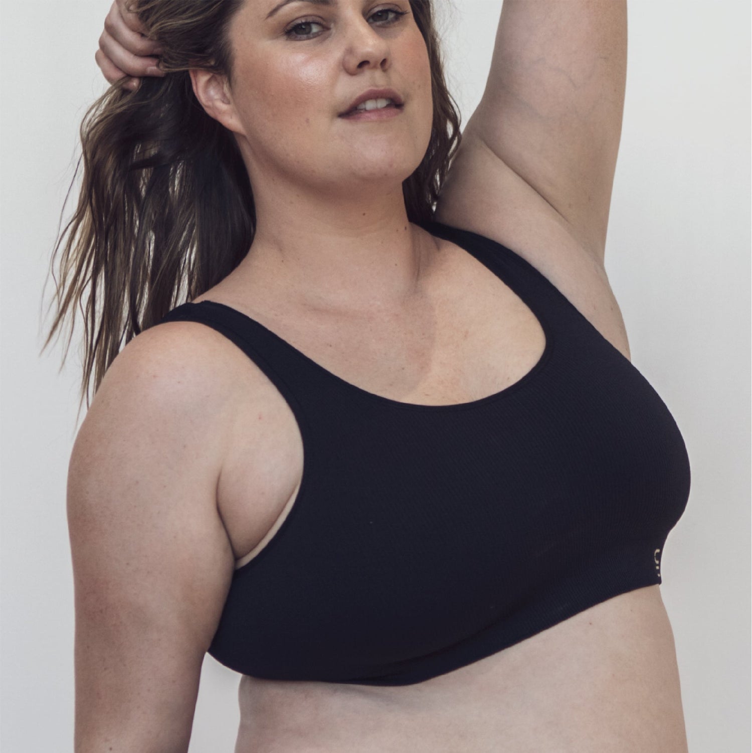 Sustainable, ethically produced Black bra crop by Underwear for Humanity: stronger support for larger bust, D - GG cup sizes. Recycled materials, knitted bra and band, seamfree, made from recycled nylon. Models wear the D+ Crop