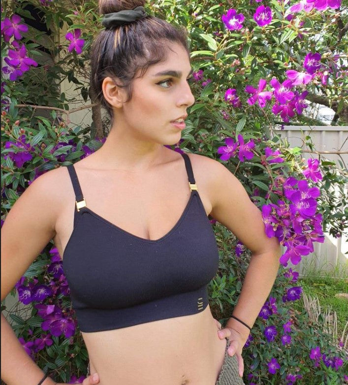 Sustainable, ethically made, black wireless maternity bra by Underwear For Humanity. A -D and DD-GG cup sizes. Recycled materials, flexible, supportive, pregnancy, feeding, convertible. Knitted bra and band, adjustable straps. Model wears maternity bra
