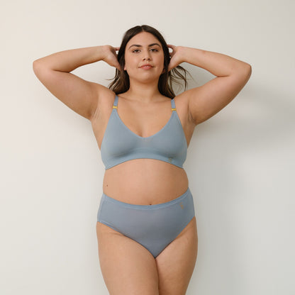 Sustainable mineral blue wireless bra by Underwear For Humanity: ethical, sustainable. A -D cup sizes. Recycled materials, flexible, supportive. Knitted bra and band, adjustable straps. Model showcases A-D bra