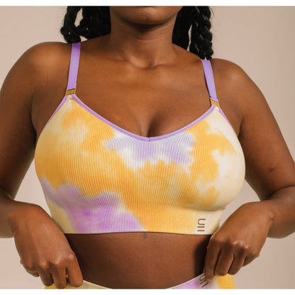 Sustainable, ethically produced sunrise - yellow, orange and purple tie dye wireless bra by Underwear for Humanity. For DD-GG cup sizes. Recycled materials, flexible, supportive. Knitted bra and band, adjustable straps. Model wears the DD+ bra.