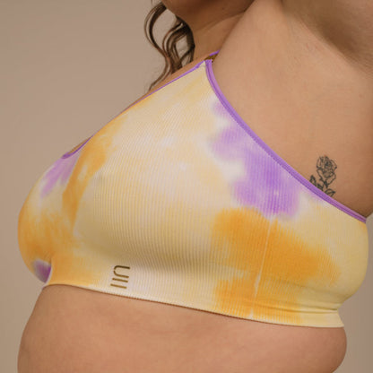 Sustainable, ethically produced sunrise - yellow, orange and purple tie dye wireless bra by Underwear for Humanity. For DD-GG cup sizes. Recycled materials, flexible, supportive. Knitted bra and band, adjustable straps. Model wears the DD+ bra.