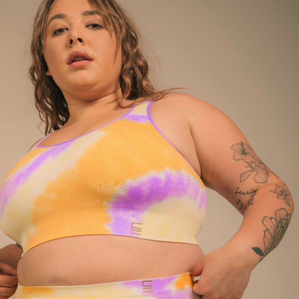 Sustainable, ethically produced sunrise- yellow orange and purple tie dye bra crop by Underwear for Humanity: stronger support for larger bust, D - GG cup sizes. Recycled materials, knitted bra and band, seamfree, made from recycled nylon. Models wear the D+ Crop