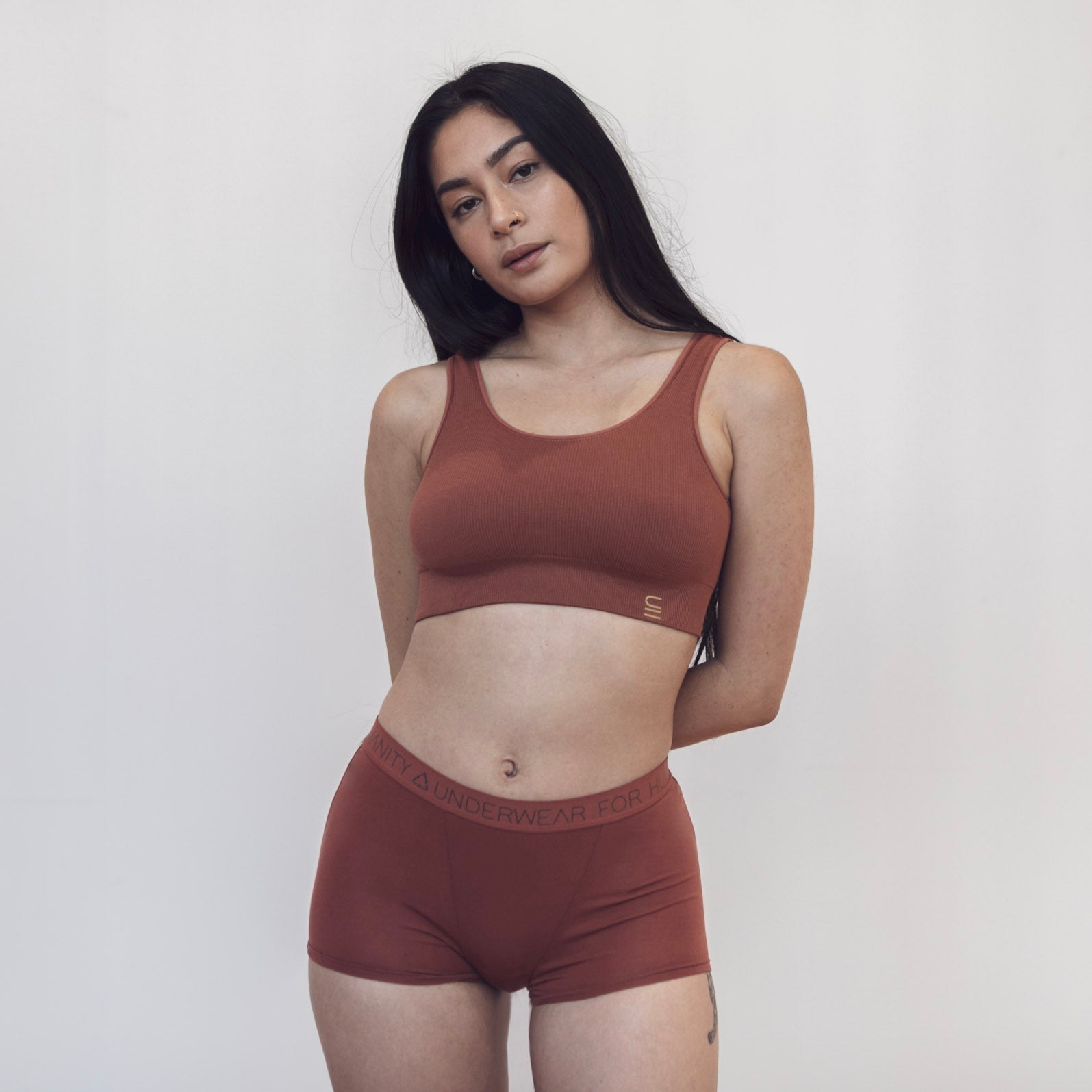 Sustainable, ethically produced clay shorts by Underwear for Humanity. Mid-rise, full coverage seat, thin, no-dig, elastic waist, short length sits higher on the leg. Made from sustainable tencel and recycled elastic. Models wear the shorts. 
