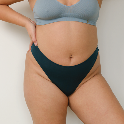 Sustainable atlantis high waist g-string by Underwear for Humanity: ethical, sustainable. sizes 6-26. Models wear high-waisted G -string underwear. underwear sits high on the waist, sits smooth on the body, made from Tencel and recycled materials.