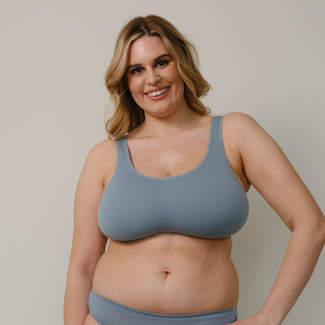 Sustainable, ethically produced mineral blue bra crop by Underwear for Humanity: stronger support for larger bust, D - GG cup sizes. Recycled materials, knitted bra and band, seamfree, made from recycled nylon. Model wears the D+ Crop