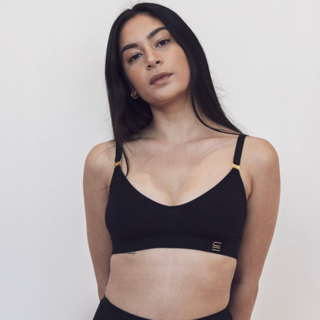 Sustainable Black wireless bra by Underwear For Humanity: ethical, sustainable. A -D cup sizes. Recycled materials, flexible, supportive. Knitted bra and band, adjustable straps. Model wears A-D bra